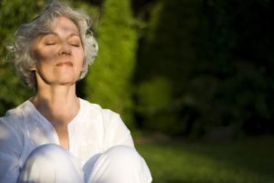 Jung gebliebene Frau genießt die abendliche Sonne