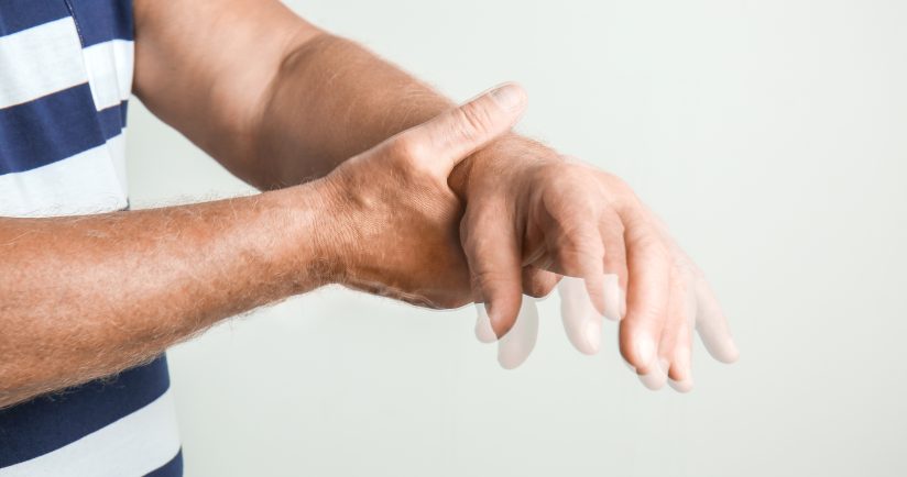 Person hält das eigene Handgelenk. Bewegungsunschärfe im Bild.